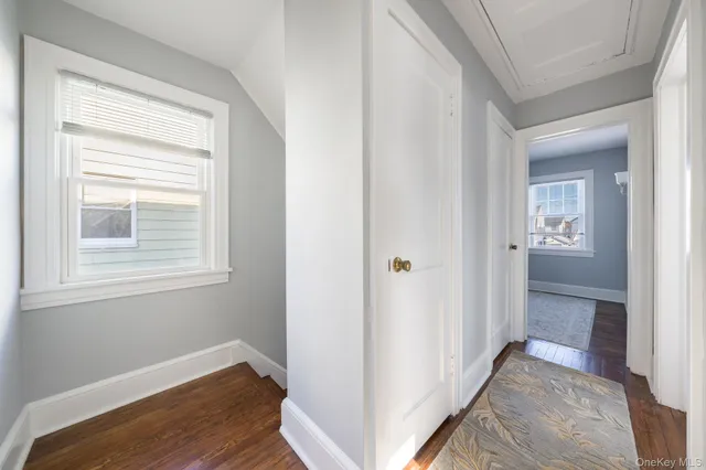 a view of hallway with bathroom and wooden floor