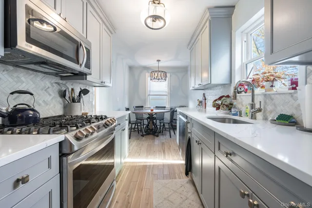 a kitchen with stainless steel appliances granite countertop a stove a sink and a microwave