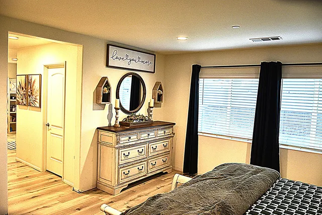 a large room with kitchen view and wooden floor