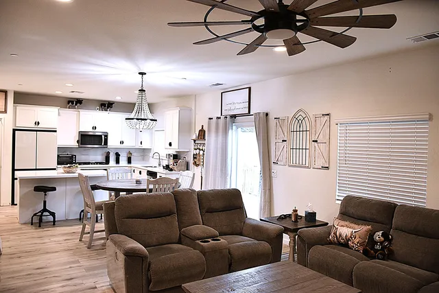 a living room with furniture kitchen view and a window