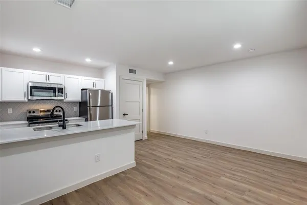 a kitchen with stainless steel appliances a refrigerator sink and microwave