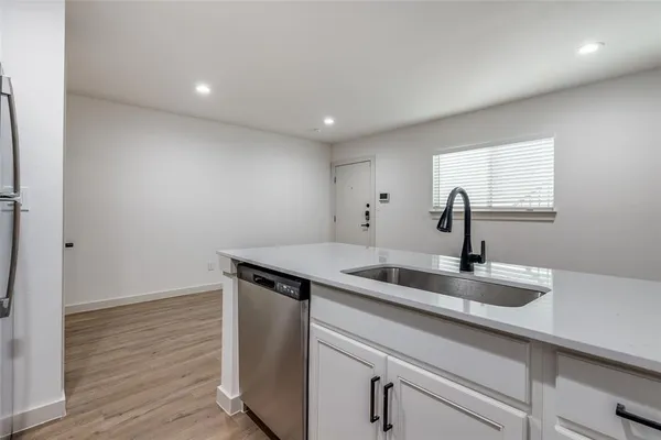 a kitchen with a sink cabinets and wooden floor