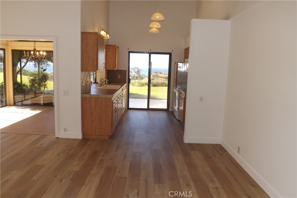 130 Avenida Adobe San Clemente, CA 92672 - Photo 8 of 26 a kitchen with wooden floors and glass door