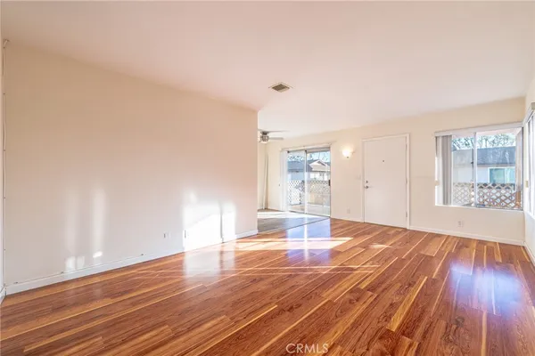a view of empty room with wooden floor