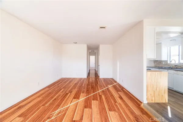 a view of a bedroom with wooden floor and a window
