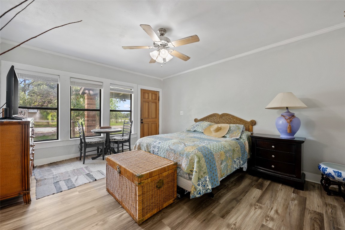 555 Hopewell Road Bertram, TX 78605 - Photo 14 of 21 Bedroom with ornamental molding, wood finished floors, and ceiling fan