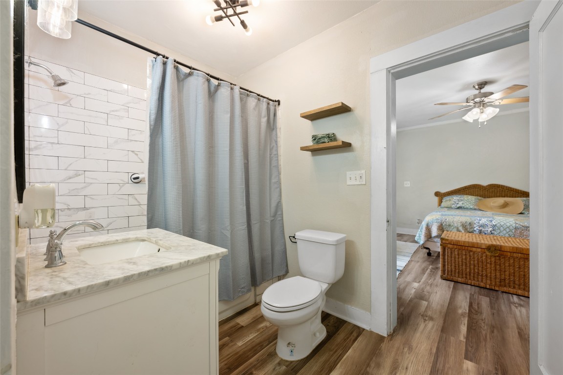 555 Hopewell Road Bertram, TX 78605 - Photo 16 of 21 Ensuite bathroom with light wood-style floors, vanity, curtained shower, and a ceiling fan