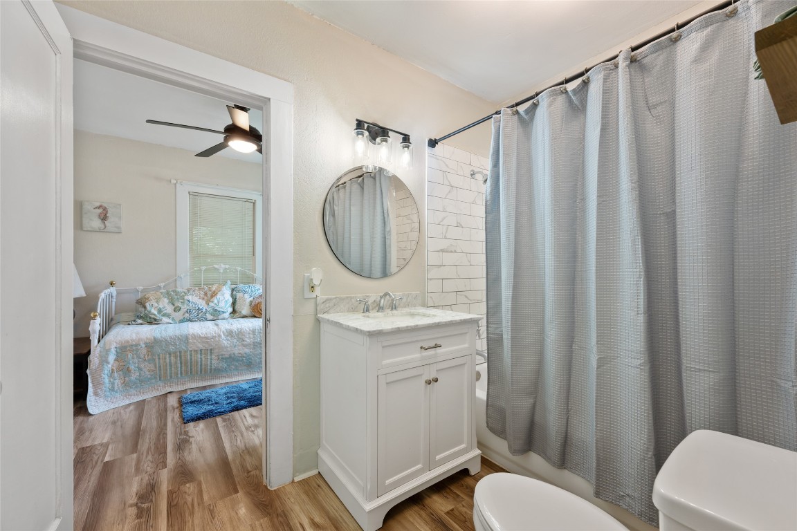 555 Hopewell Road Bertram, TX 78605 - Photo 17 of 21 Ensuite bathroom with light wood finished floors, shower / bath combo with shower curtain, vanity, and ceiling fan