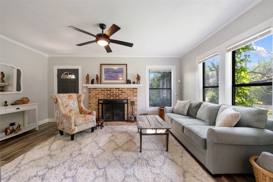555 Hopewell Road Bertram, TX 78605 - Photo 6 of 21 Living area with crown molding, a fireplace, wood finished floors, and ceiling fan