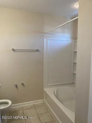 a bathroom with a tub and toilet