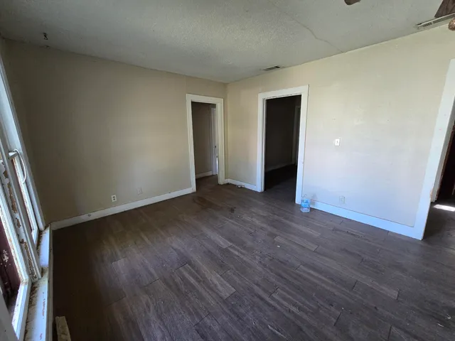 an empty room with wooden floor and closet