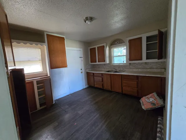 a kitchen with kitchen island granite countertop wooden cabinets and a sink