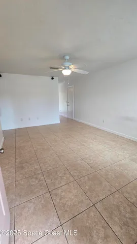 a view of a room with an empty space and a ceiling fan