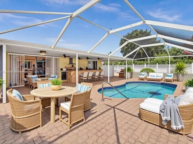 a view of a patio with table and chairs potted plants and large tree