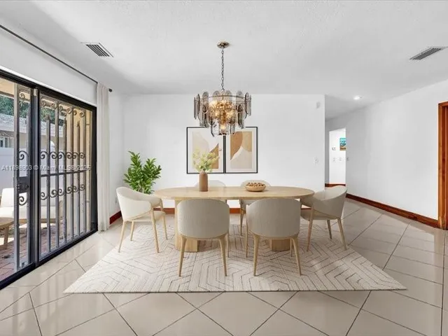 a dining room with furniture a chandelier and window