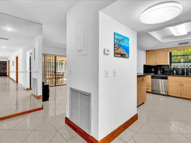a kitchen with stainless steel appliances granite countertop white cabinets sink and window