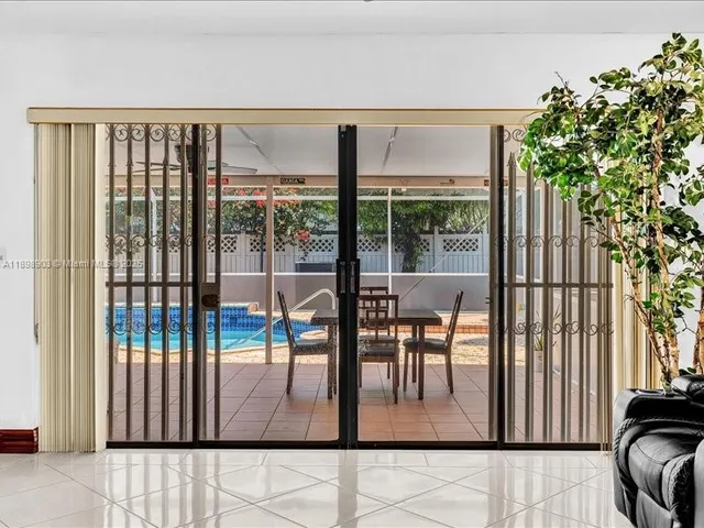 a view of a dining space with furniture and floor to ceiling window