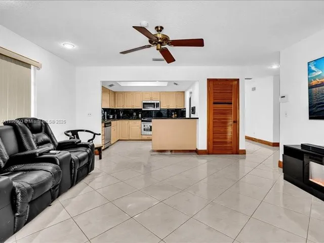 a living room with furniture and kitchen view