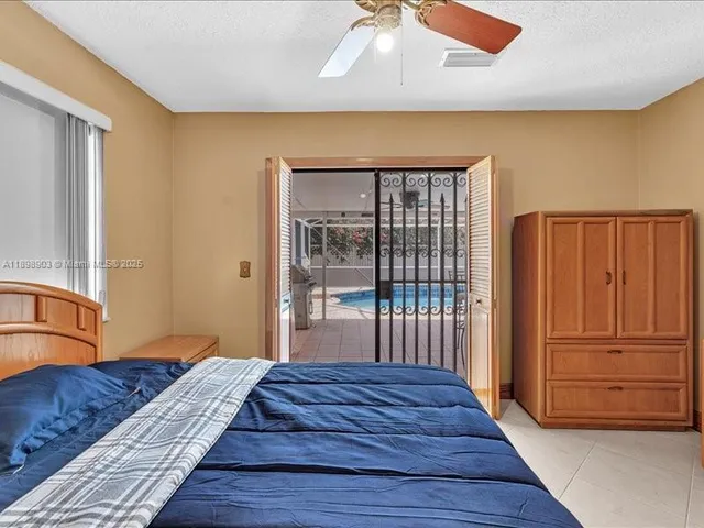a bedroom with a large bed a chandelier and windows