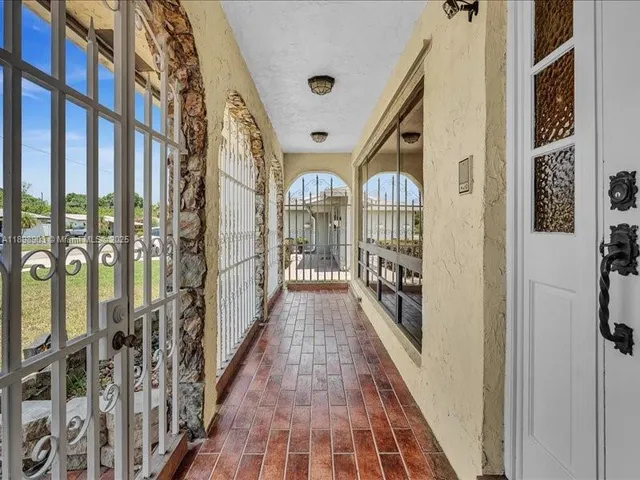 a view of a hallway with wooden floor and windows