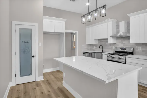 a kitchen with stainless steel appliances a white stove top oven and cabinets
