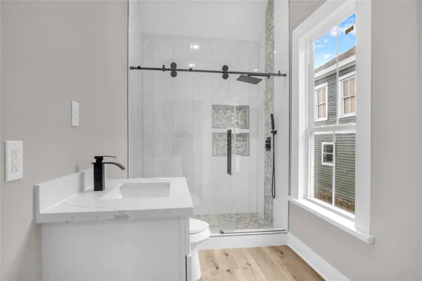 a bathroom with a sink a toilet and shower