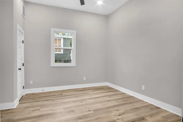 a view of a hallway with wooden floor and a living room