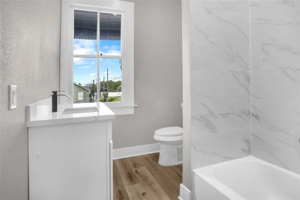 a bathroom with a tub sink and mirror