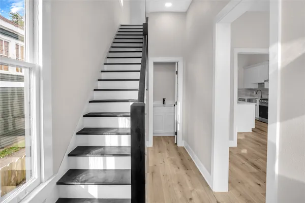 a view of a hallway with wooden floor and windows