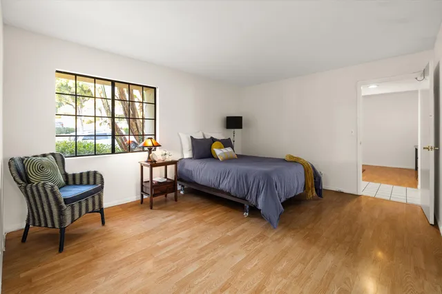 a bedroom with a bed and wooden floor