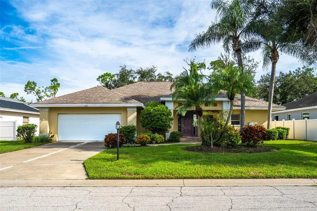 front view of house with potted plants and palm trees
