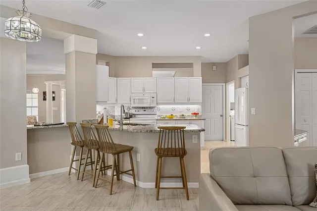 a kitchen with a table chairs refrigerator and microwave