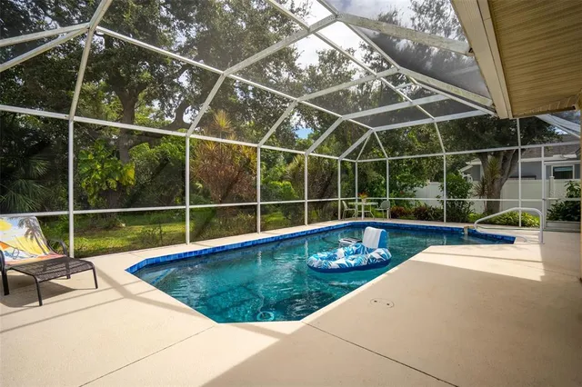 a view of a swimming pool with a couch and wooden fence