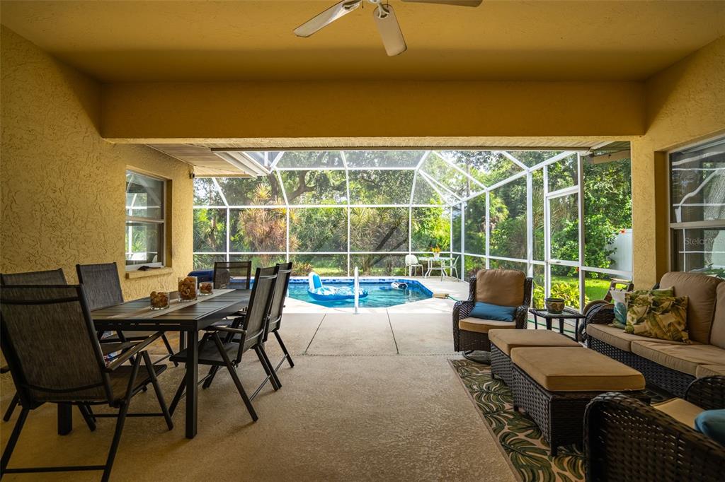 603 Pine Ranch East Road Osprey, FL 34229 - Photo 10 of 37 a view of a patio with couches potted plants and a dining space