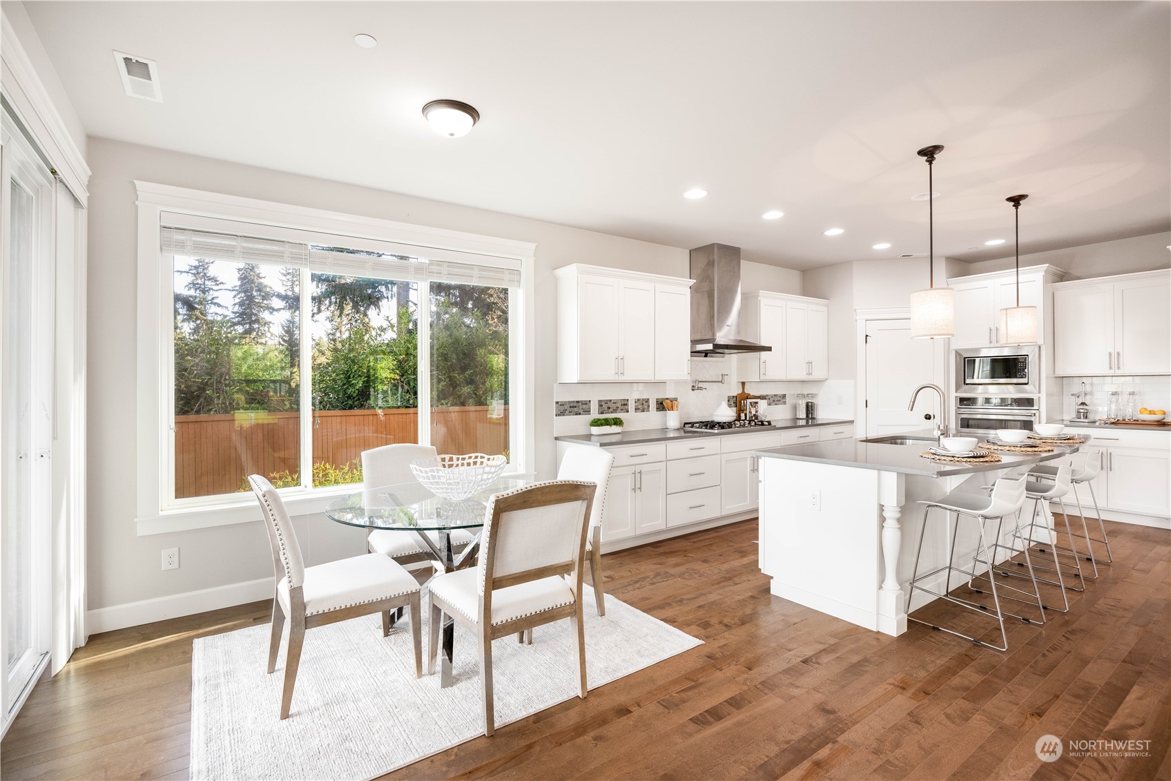 234 239th Street Southeast Bothell, WA 98021 - Photo 11 of 38 a kitchen with stainless steel appliances granite countertop a stove a refrigerator a kitchen island with a dining table and chairs