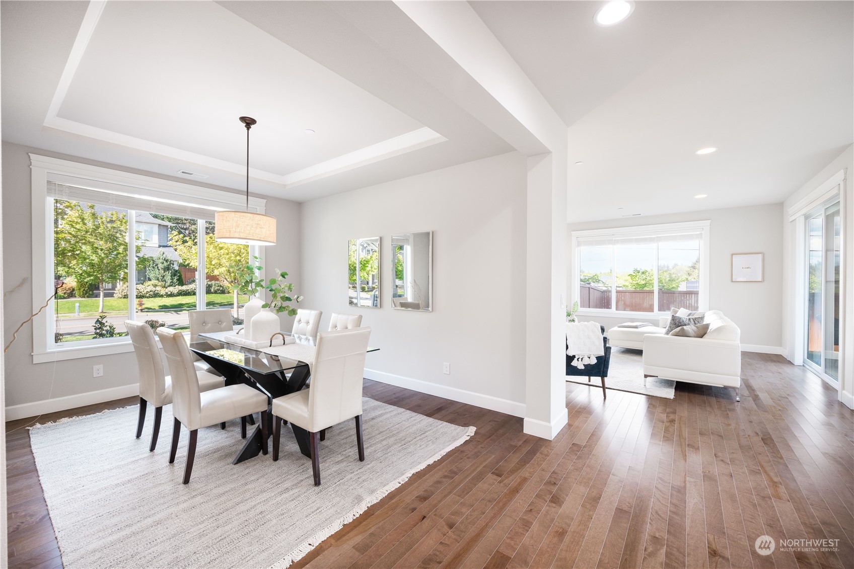 234 239th Street Southeast Bothell, WA 98021 - Photo 15 of 38 a dining room with wooden floor a chandelier a glass table and chairs