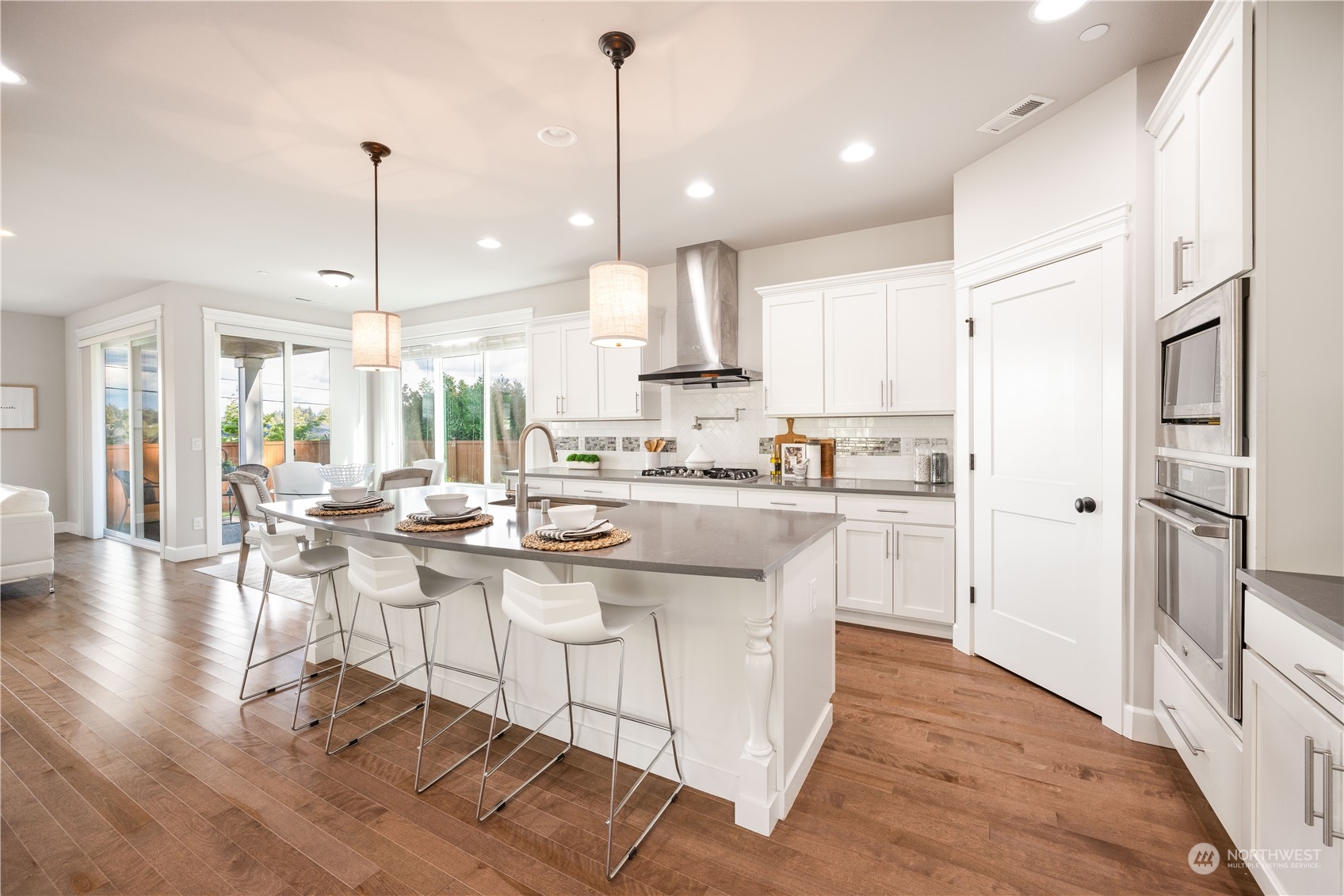 234 239th Street Southeast Bothell, WA 98021 - Photo 10 of 38 a kitchen with stainless steel appliances granite countertop a stove a sink a refrigerator and white cabinets with wooden floor