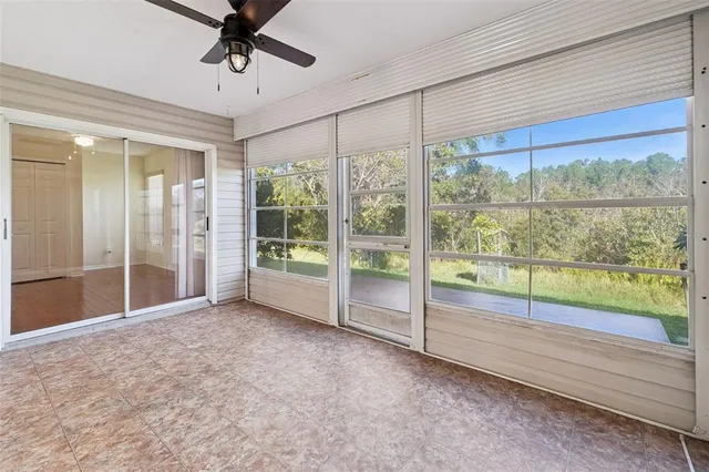 an empty room with floor to ceiling windows and outdoor view