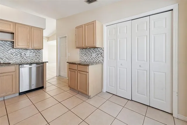 a kitchen with white cabinets and sink