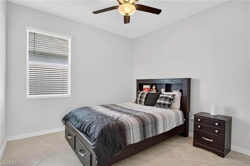 2130 Hamlin Street Naples, FL 34120 - Photo 22 of 40 a bedroom with a bed and a chandelier