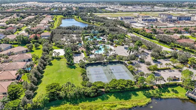 an aerial view of residential houses with outdoor space and trees
