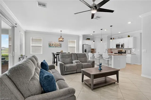 a living room with furniture kitchen and a chandelier