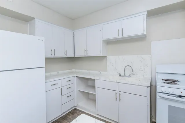 a kitchen with white cabinets and white appliances