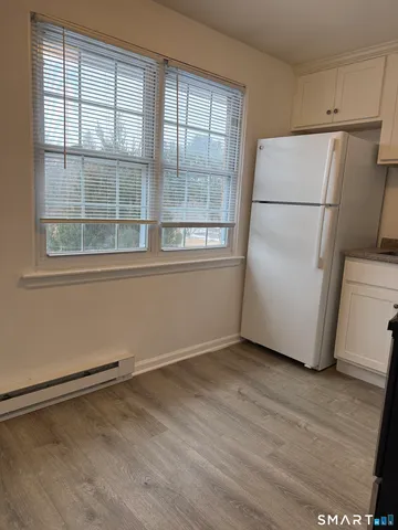 a view of a kitchen with wooden floor and a refrigerator