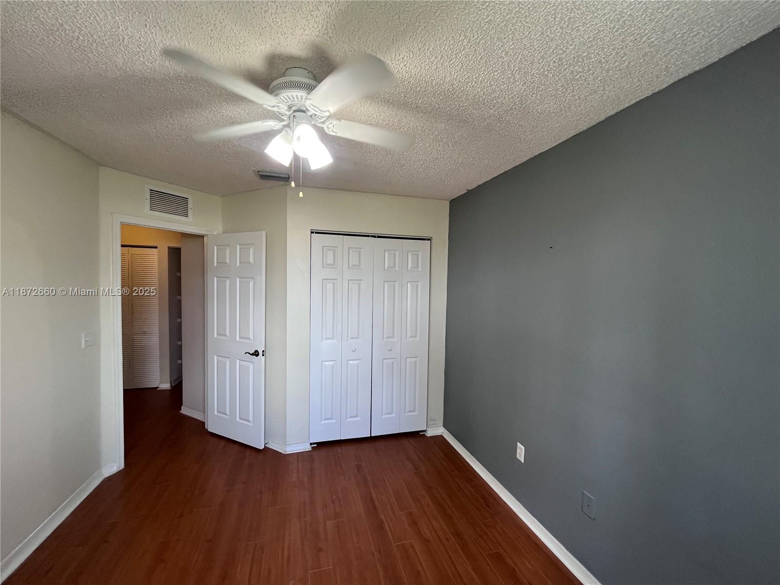 2320 Southeast 23rd Road, Unit 2320 Homestead, FL 33035 - Photo 14 of 20 an empty room with wooden floor fan and windows