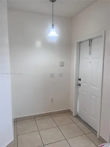 a view of an empty room with closet and mirror