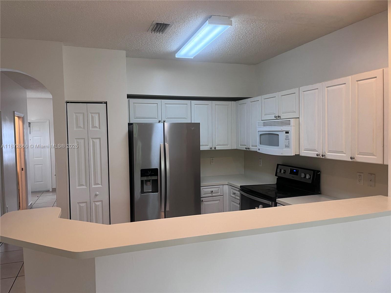 2320 Southeast 23rd Road, Unit 2320 Homestead, FL 33035 - Photo 8 of 20 a kitchen with stainless steel appliances a refrigerator and a stove