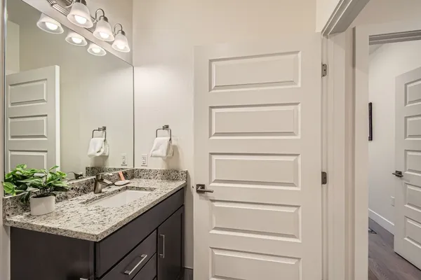a bathroom with a granite countertop sink and a mirror