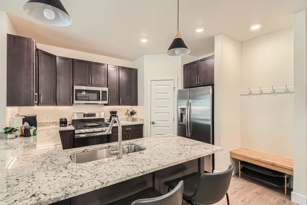 a kitchen with stainless steel appliances granite countertop a stove refrigerator and a sink