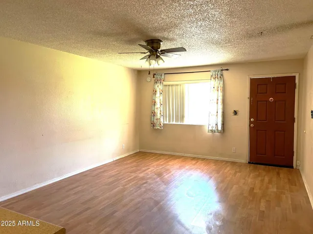 an empty room with windows and a ceiling fan